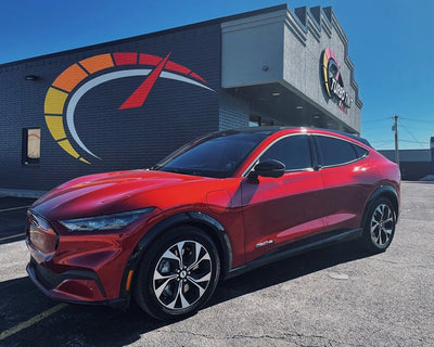 Red SUV car with Automotive window tint Infront of Turbo Tint logo and building sun